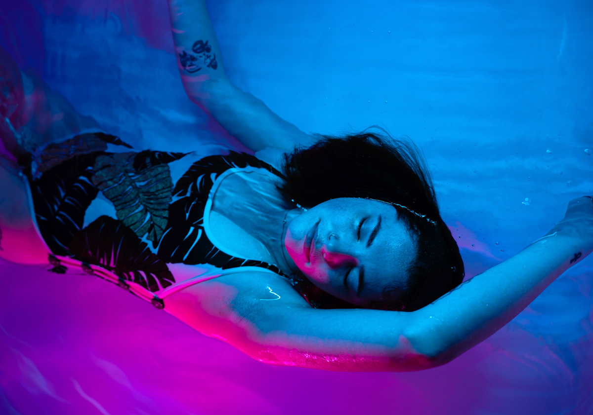 Person relaxing in a float pod filled with Epsom salt solution.