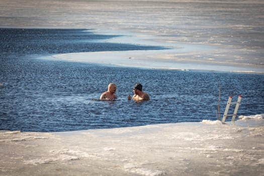 Two men in ice cold water contrasted with the advanced vasodilation and DOMS recovery London provided by Float Hub pods.