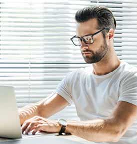 Man sitting at a desk focused and working on a laptop after float therapy session