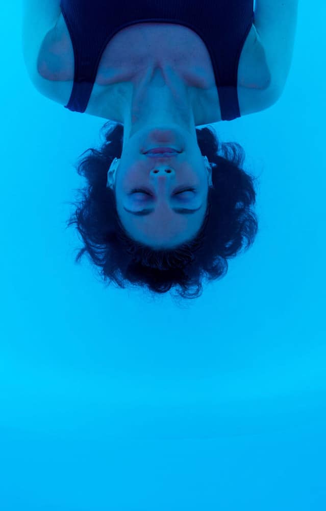 Woman floating on back in water of floatation tank in London