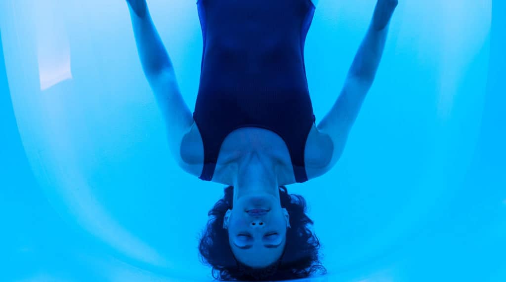 Woman floating on back in water of floatation tank in London